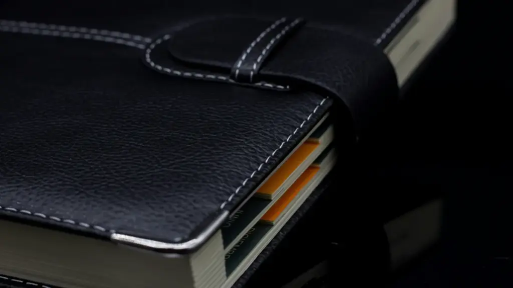 Close-up of black leather notebook with strap and index tabs