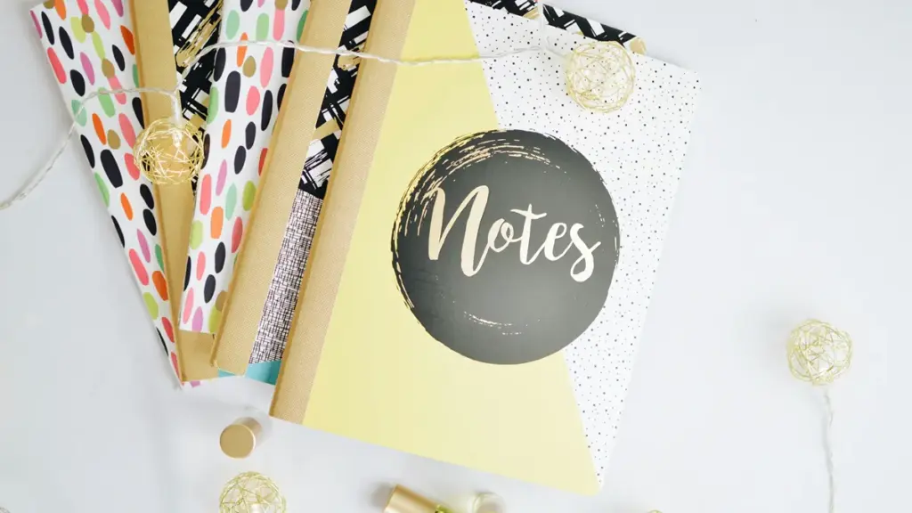 Colorful patterned notebooks with string lights on a white background