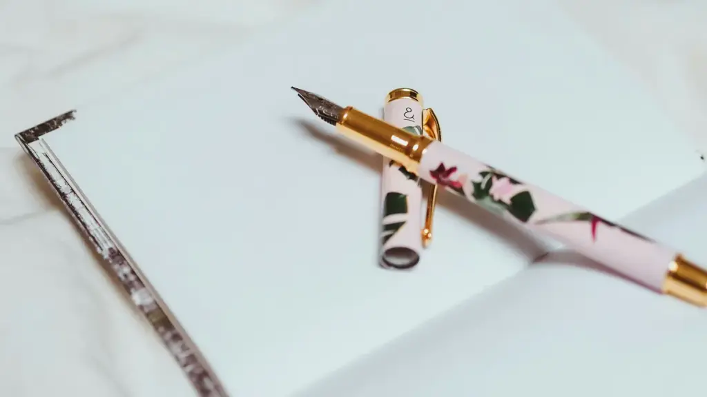 Floral fountain pen resting on an open blank notebook page