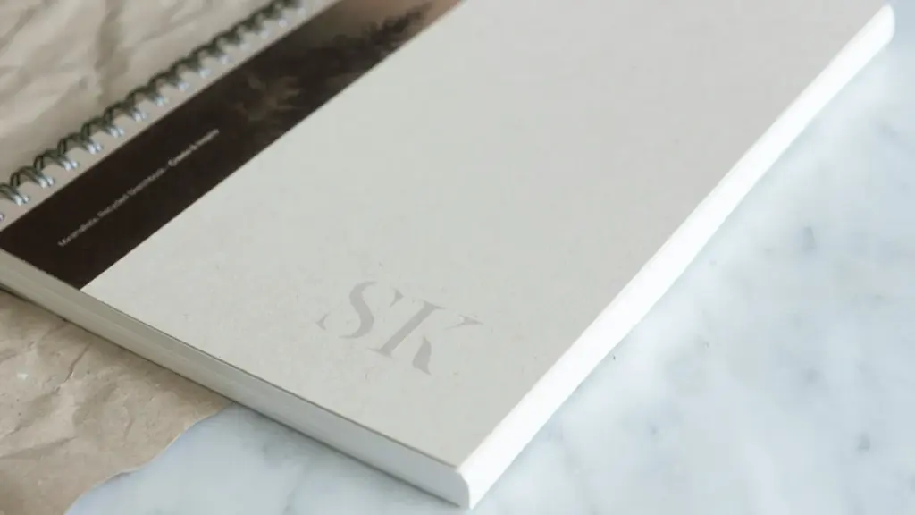 Minimalist paper cover spiral sketchbook with SK logo on marble surface