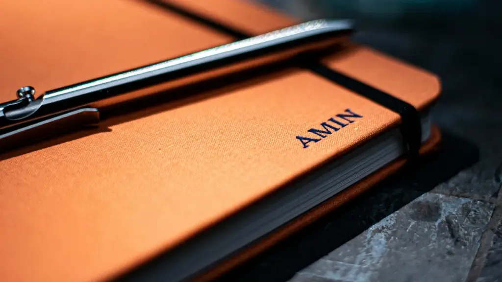 Orange cloth cover hardcover notebook with silver pen resting on top