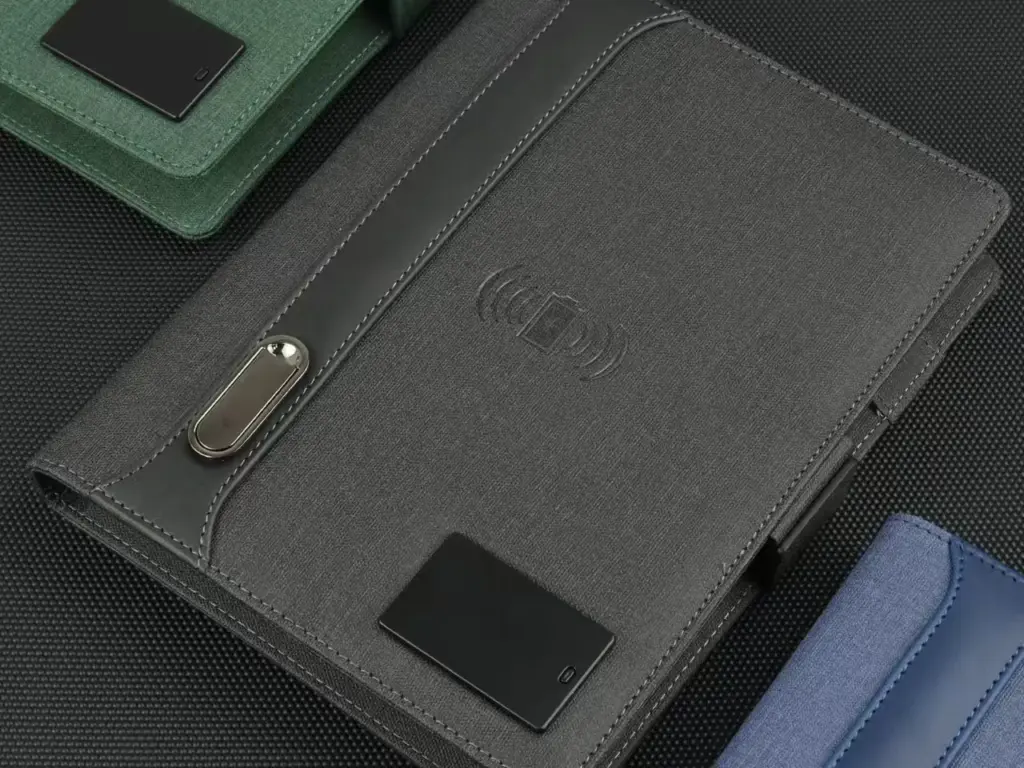 Grey smart notebook featuring an NFC symbol, magnetic clasp, and fabric texture, with green and blue options visible.